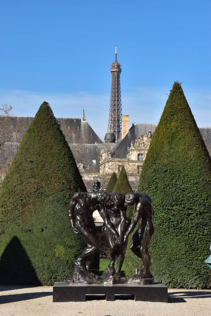 Die Drei Schatten von Rodin überragt vom Eiffelturm