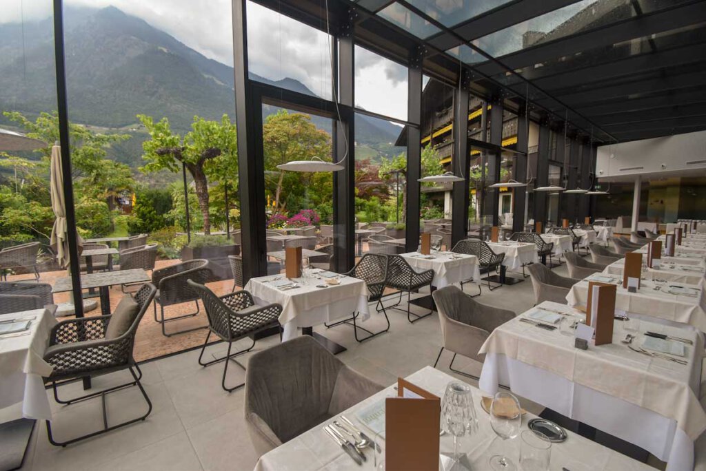 Speisesaal und Terrasse des Hotels Wiesenhof in Algund mit Bergblick