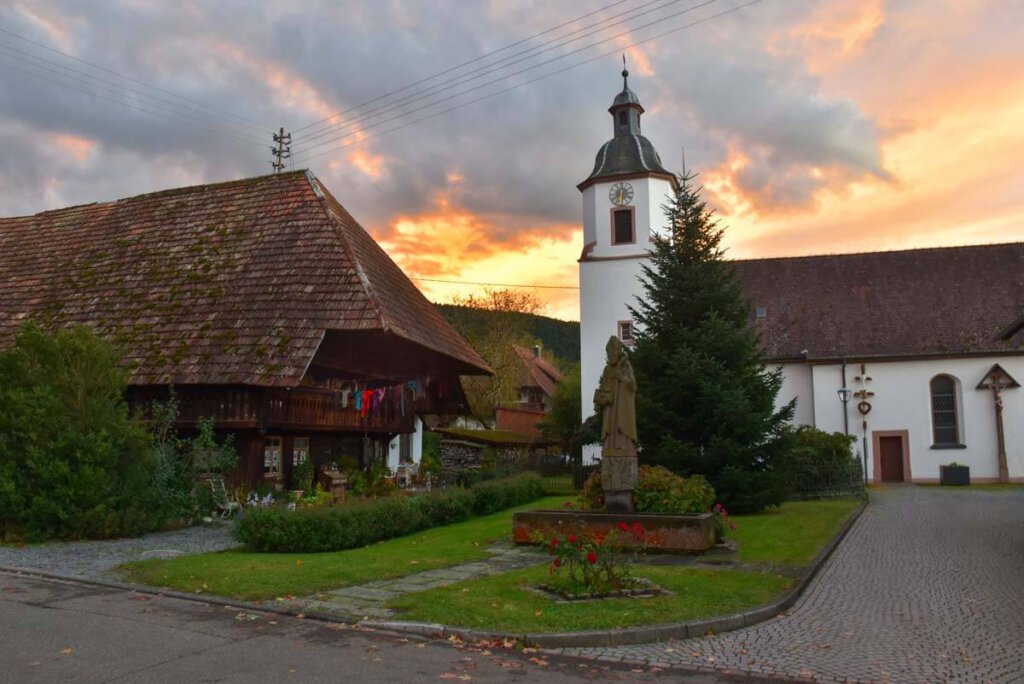 Abendstimmung im Schwazwälder Bauerndorf Unterentersbach mit Kirche, Dorfbrunnen und Schwarzwaldhof