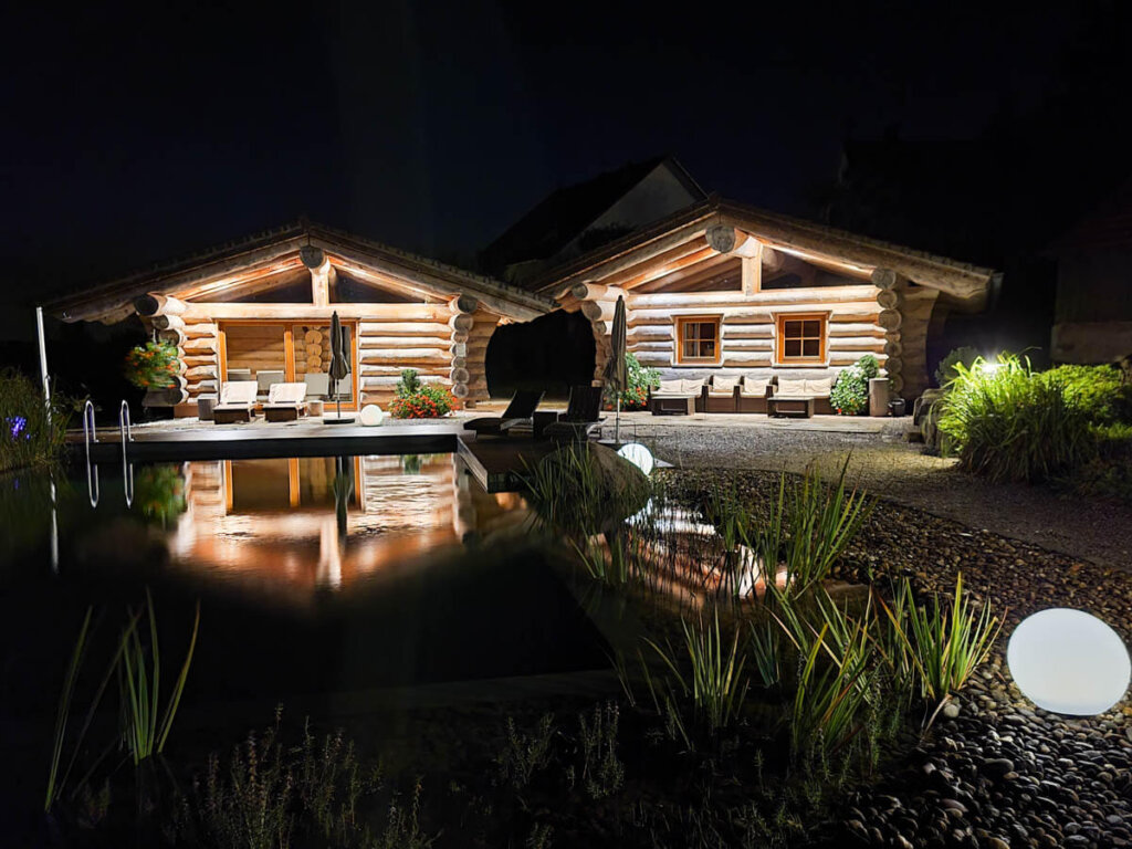 Abendstimmung am Naturteich mit Blockhütten im Hotel Konradshof in Seewald-Besenfeld