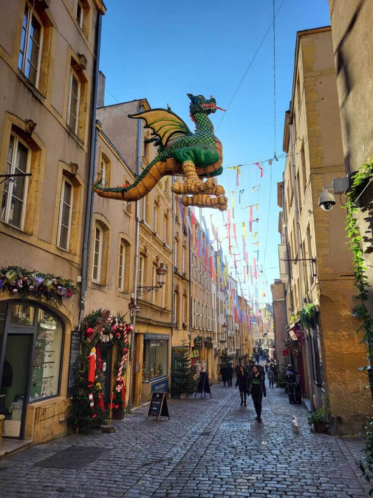 Drache Graoully fliegt über der Rue Taison in Metz' Altstadt