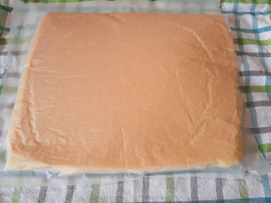 Abziehen des Backpapiers vom Biskuit