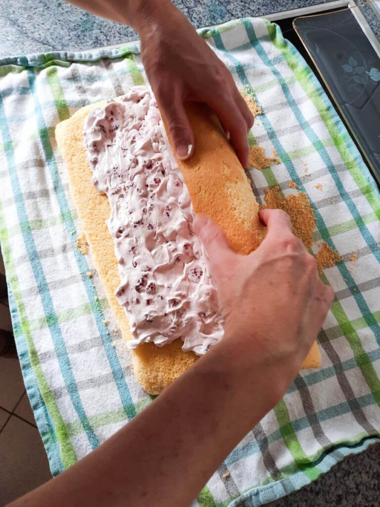 Aufrollen der gefüllten Biskuitplatte