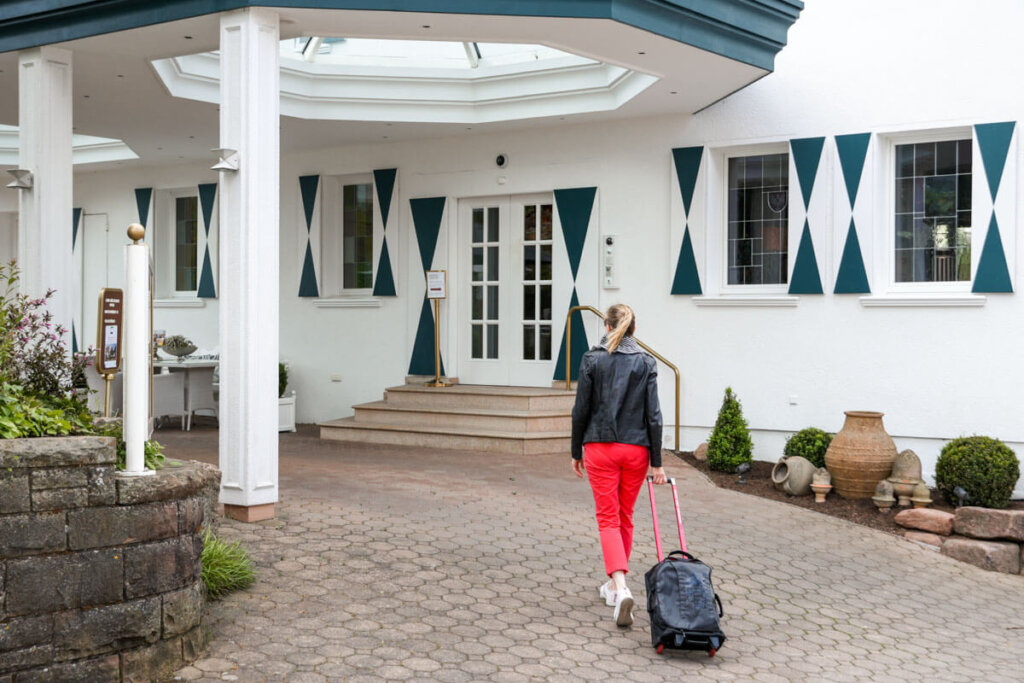 Mit Handgepäckkoffer auf dem Weg zum Check-In im Hotel