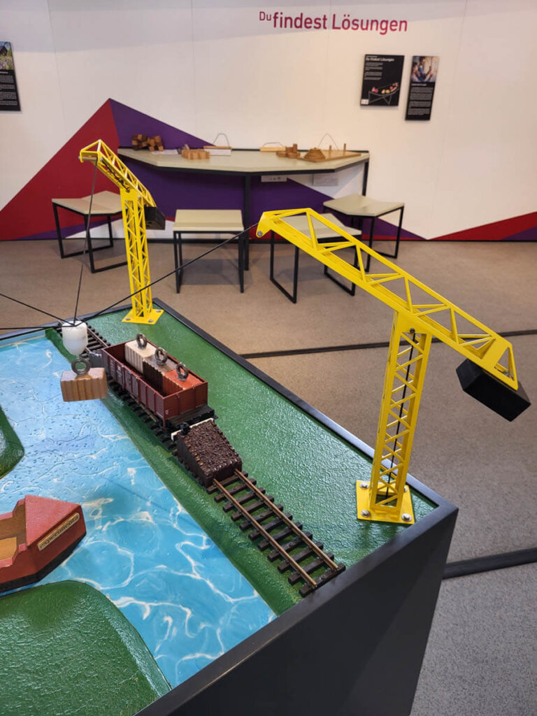 Zusammenarbeit beim Beladen eines Zugs per Kran