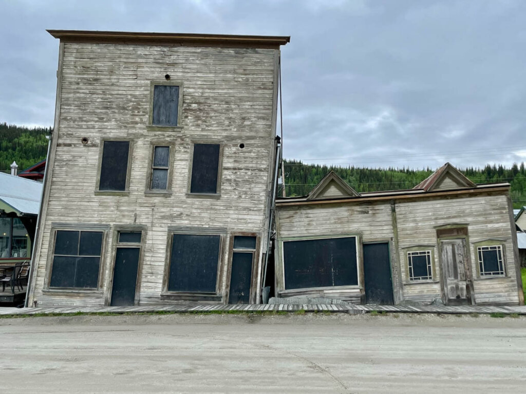 Windschiefe Häuser im Dawson City,, die der Permafrost bewegt