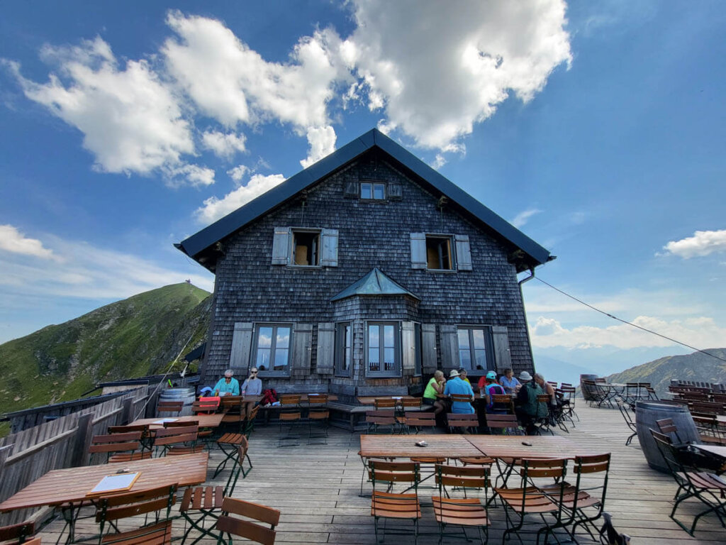 Auf der Terrasse der Kellerjochhütte in Schwaz, Tirol, mit Kapelle links hinten